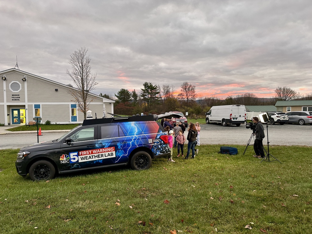 NBC 5’s First Warning Weather Lab vehicle is parked outside Benson Village School at sunrise as a camera crew films students gathered for a segment.