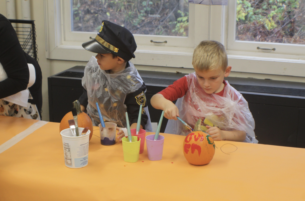 One student dressed as a police officer and another in red paint pumpkins during the activity.
