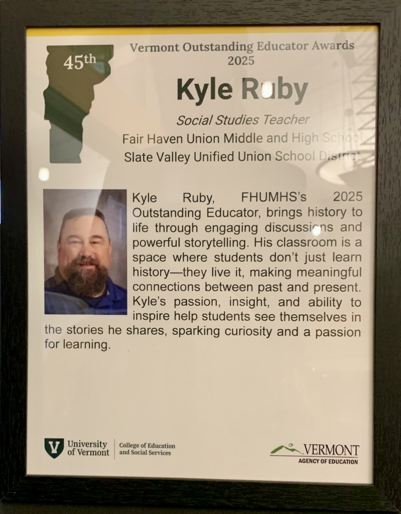 A framed Vermont Outstanding Educator Award honoring Kyle Ruby, featuring his portrait and a written tribute to his work at Fair Haven Union Middle and High School.