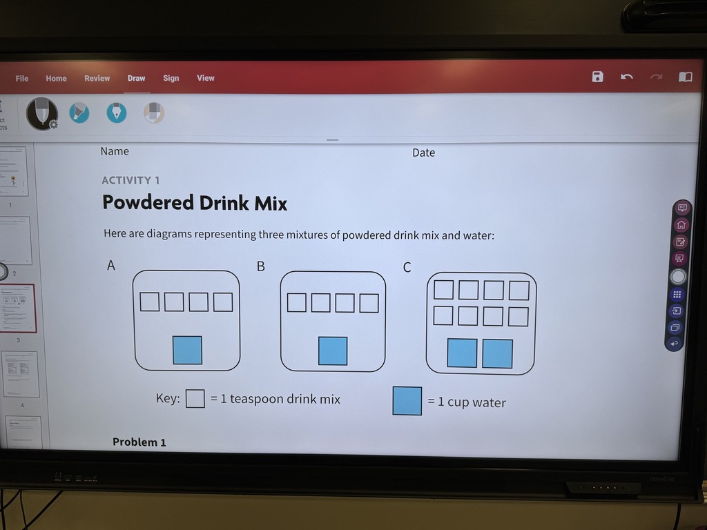 A clear close-up image of a smartboard displaying the math activity titled "Powdered Drink Mix." The screen shows three diagrams labeled A, B, and C, representing mixtures. The Key is visible: a white square equals "1 teaspoon drink mix," and a blue square equals "1 cup water." Diagram A has 4 drink mix squares and 1 water square. Diagram B has 4 drink mix squares and 1 water square. Diagram C has 8 drink mix squares and 2 water squares.