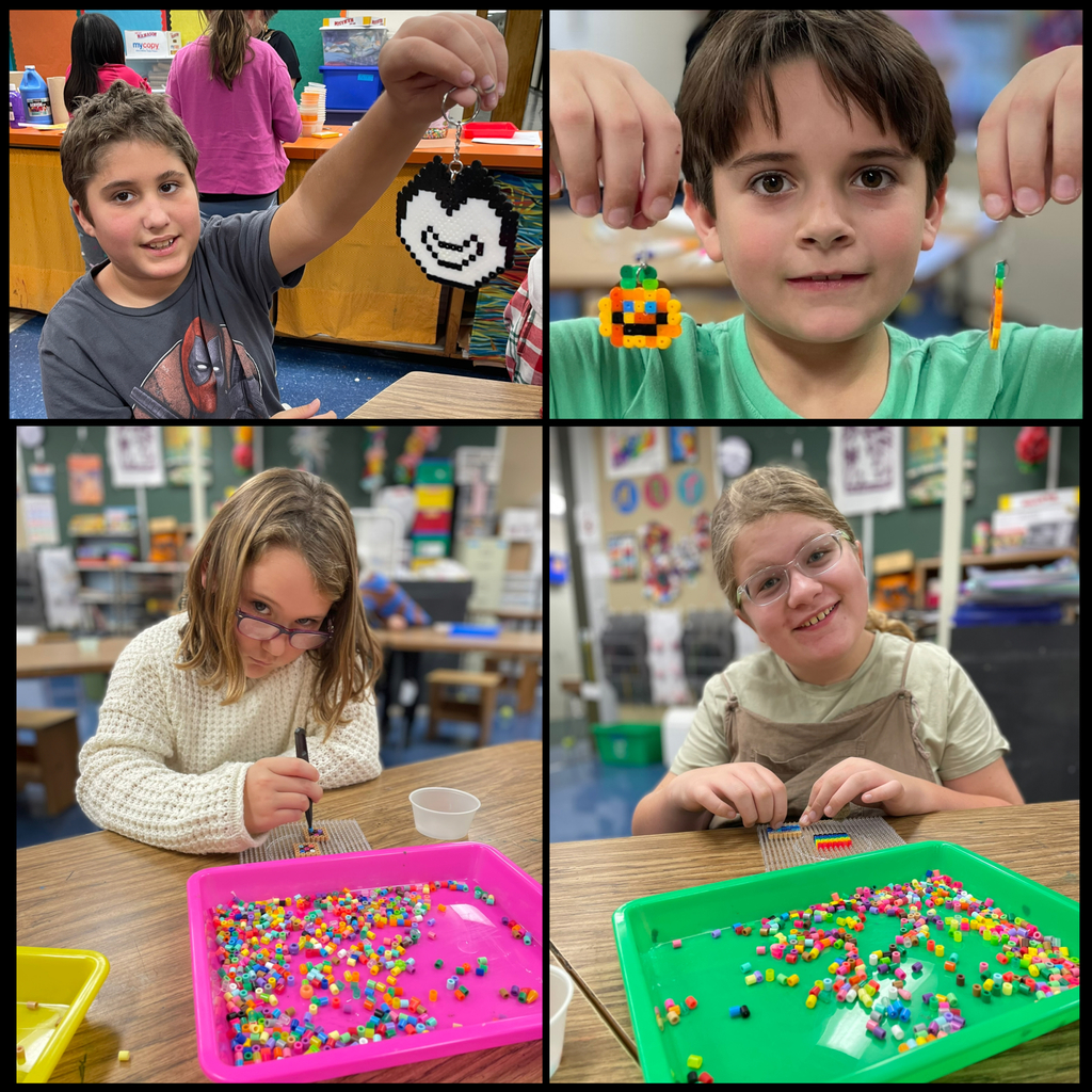 collage of 4 images: Image 1 (Top-left collage square)  A boy sitting at a classroom table proudly holds up a large Perler bead keychain shaped like a smiling face. Bright colors and activity materials fill the background.  Image 2 (Top-right collage square)  A student holds up two small Perler bead creations—a pumpkin charm and a long, thin bead design—while smiling at the camera.  Image 3 (Bottom-left collage square)  A girl wearing glasses and a cream sweater leans over a tray of colorful Perler beads, carefully arranging beads onto a clear pegboard.  Image 4 (Bottom-right collage square)  A student smiles while arranging red and green Perler beads on a clear pegboard, with a tray of brightly colored beads in front of her.