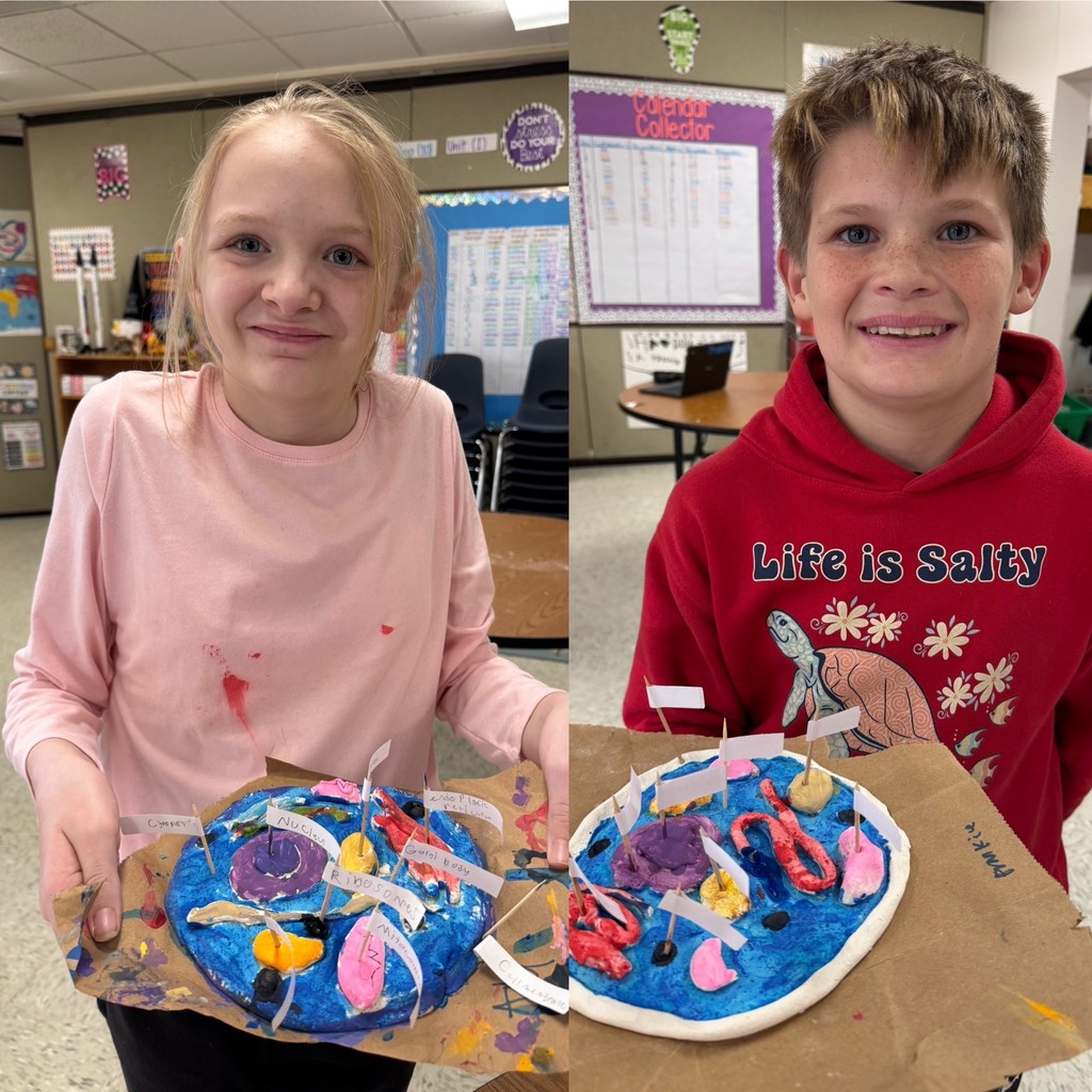 "A composite photo of two students, a girl and a boy, smiling while holding their 3D, brightly colored cell models on brown paper bags." 