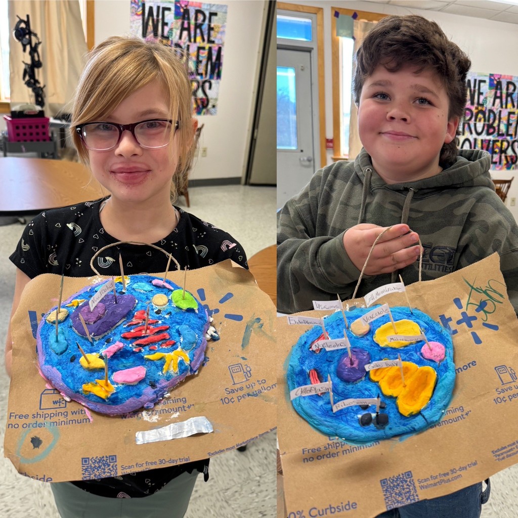  "A composite photo of two students, a girl and a boy, smiling while holding their 3D, brightly colored cell models on brown paper bags.
