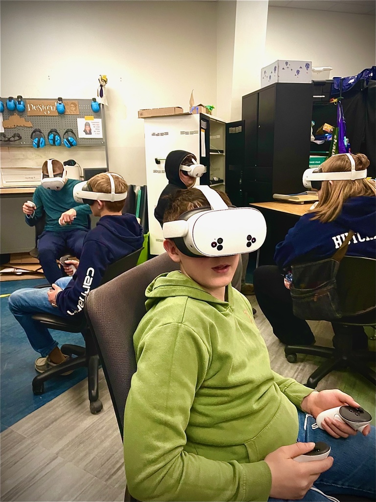 Students sit in rolling chairs wearing VR headsets and holding controllers in the Design Lab.