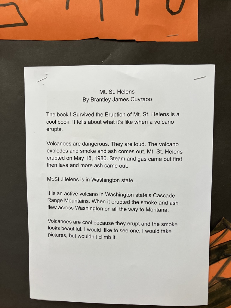 A printed report titled "Mt. St. Helens"  The student writes about the 1980 eruption in Washington state, describing the smoke and ash, and mentions reading the book I Survived the Eruption of Mt. St. Helens.