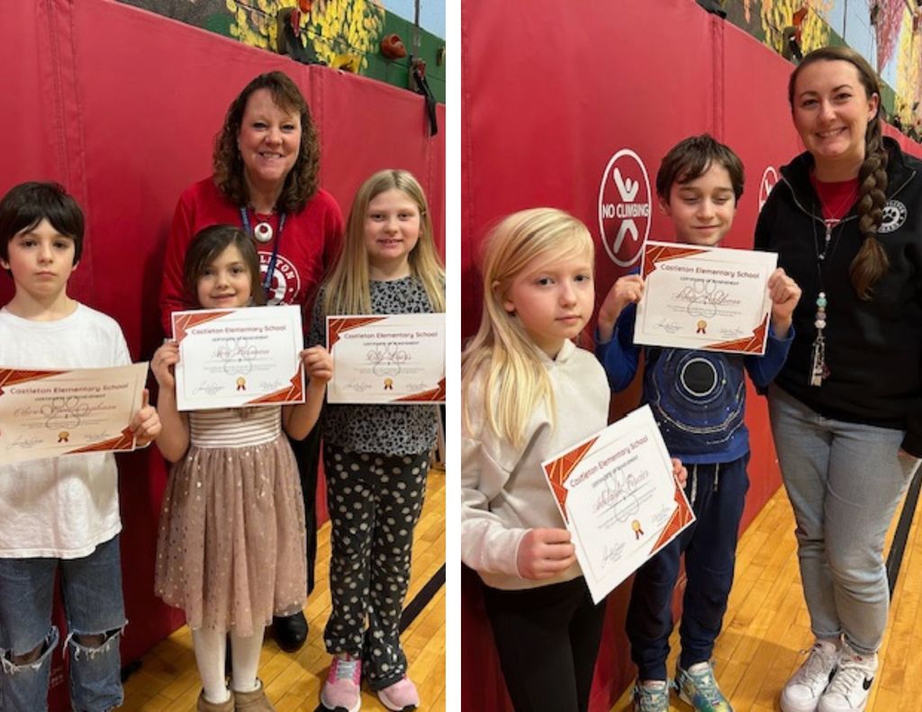 Three elementary students hold certificates while standing with a staff member in a gymnasium, smiling in front of red wall mats.