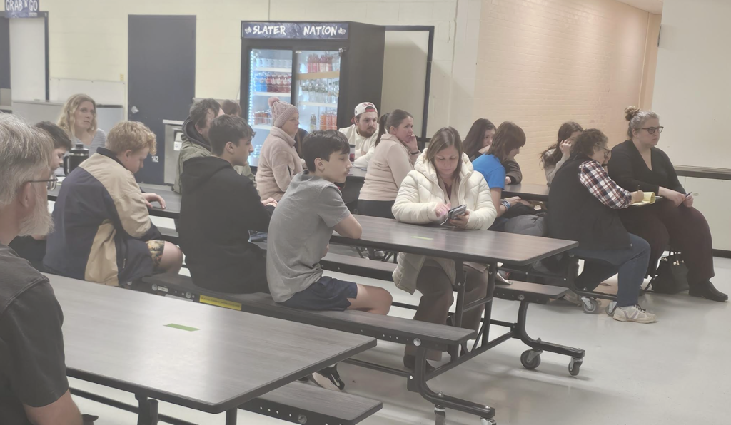 Parents, guardians, and students gather in the school cafeteria, seated at long tables during Course Selection Night.