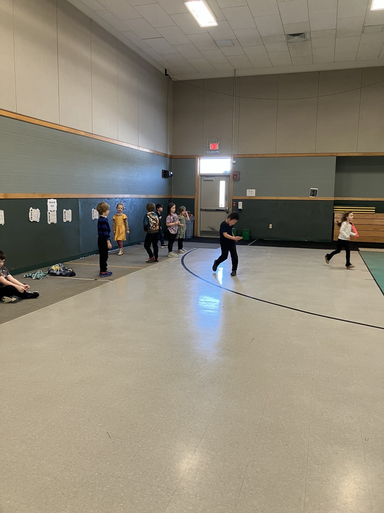These images showcase children participating in various supervised indoor activities within a school gymnasium or multipurpose room