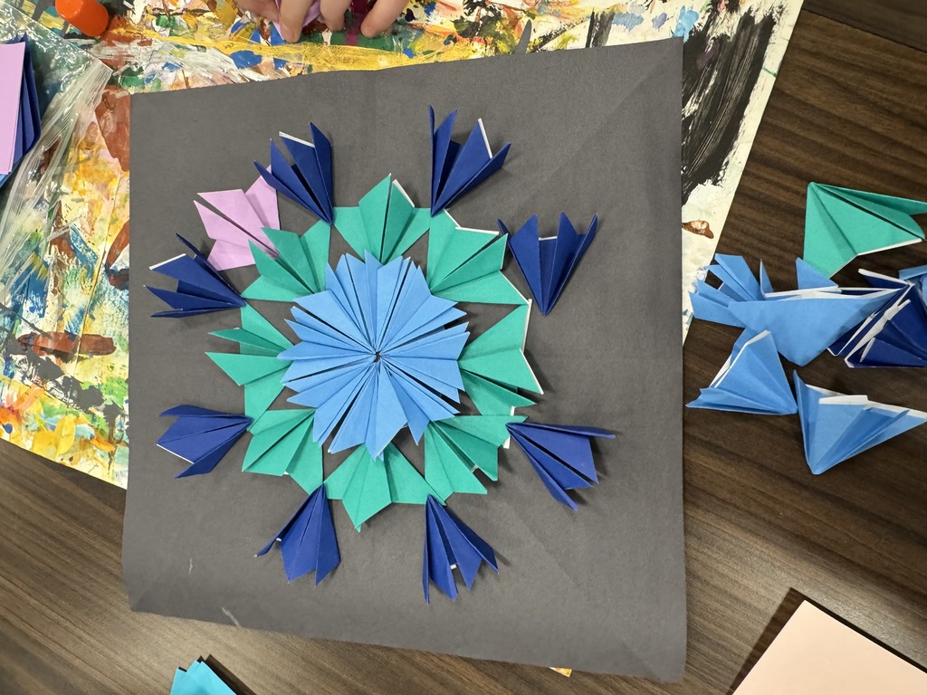 These images highlight intricate paper-folding projects, often referred to as Iris Folding or modular origami, created by students in a school setting.