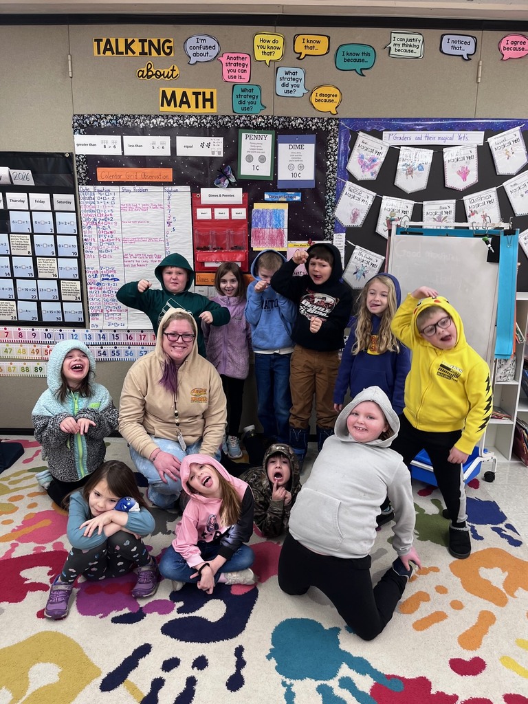 These images show a group of ten students and one teacher posing in a primary school classroom featuring a strong emphasis on mathematics and student creativity.