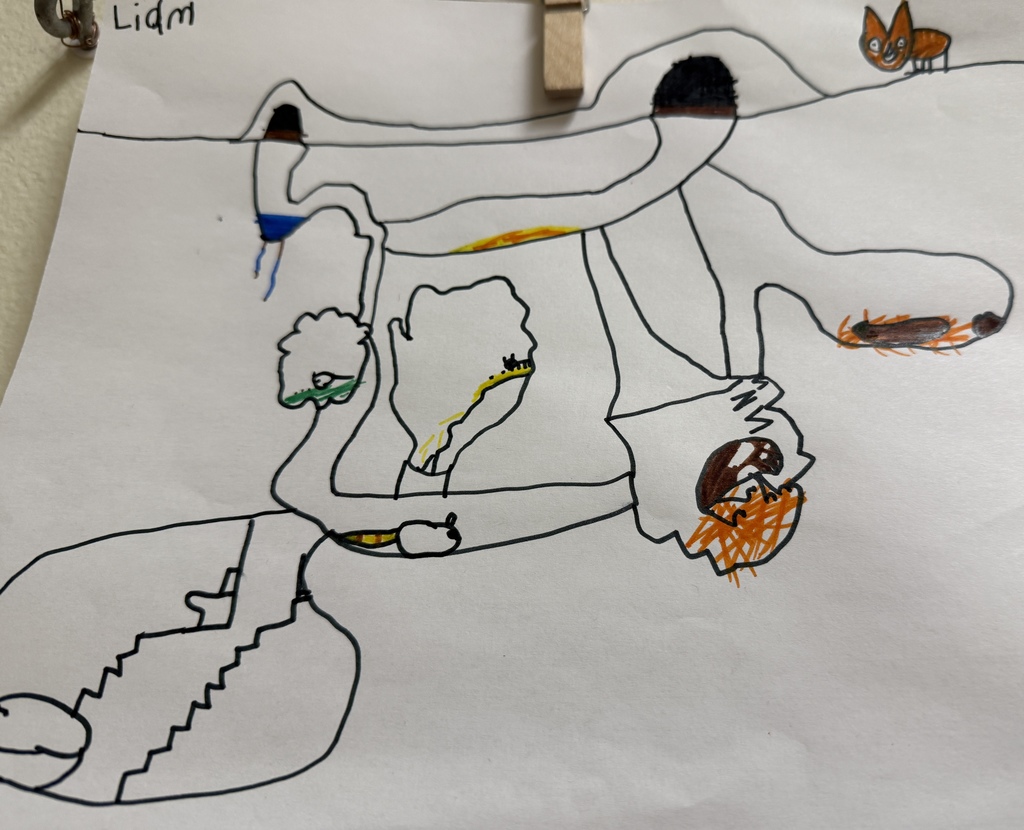 Child’s colored drawing of a detailed underground burrow scene with multiple chambers, tunnels, and animals, clipped to a display line.