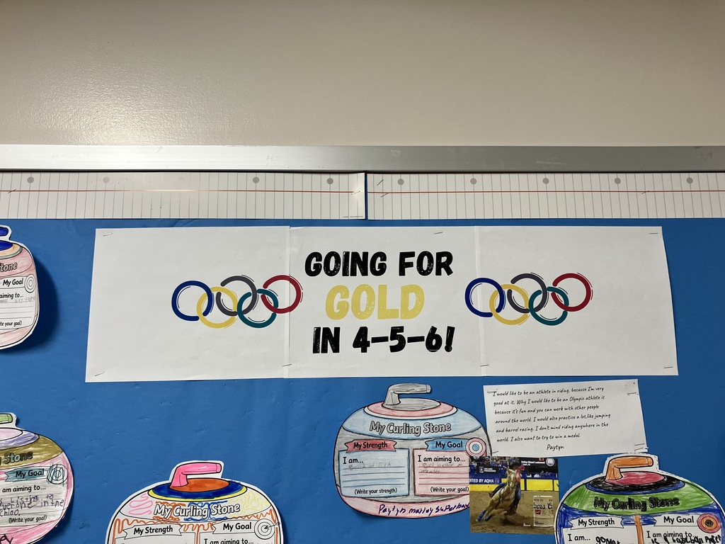  Bulletin Board Overview Context: A blue bulletin board features a large banner at the top with the Olympic rings and the text "GOING FOR GOLD IN 4-5-6!"  Layout: Below the banner are several hand-colored paper cutouts shaped like curling stones. Each stone is divided into two sections: "My Strength" and "My Goal."  Details: One stone by a student  lists a strength in "ELA" and a goal to "get better at math." Next to it is a printed essay and a small photograph of a person competing in barrel racing on a horse.  