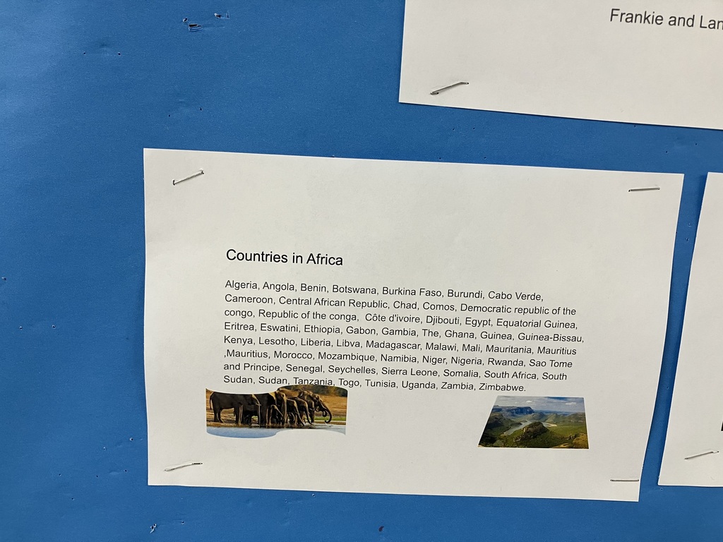  poster titled "Countries in Africa" listing dozens of nations in alphabetical order, from Algeria to Zimbabwe. Two small photos at the bottom show a line of elephants at a watering hole and a scenic canyon vista.  