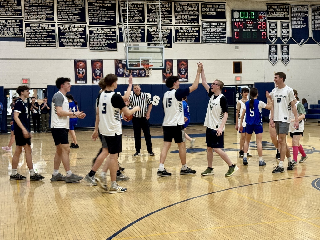Players from both teams exchange high-fives on the court after a play during the Unified Basketball game.