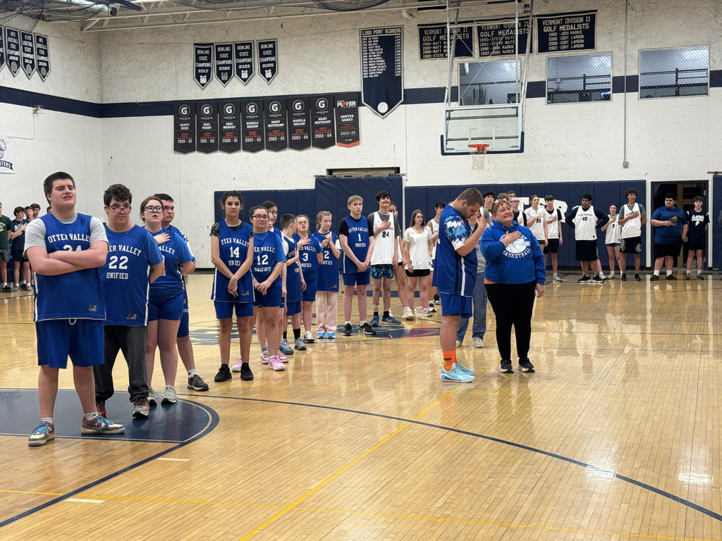 Two Unified Basketball teams stand in lines on the court during what appears to be pre-game or halftime recognition.