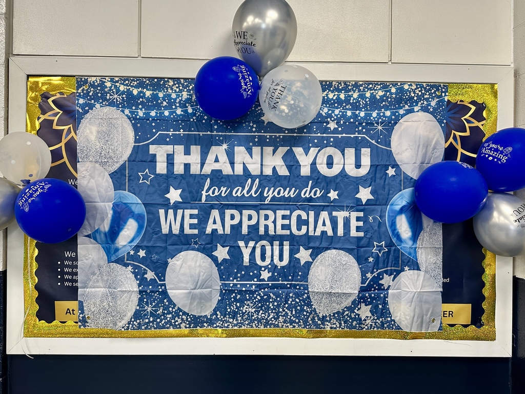 A decorative bulletin board reads “Thank you for all you do, we appreciate you” surrounded by blue and silver balloons.