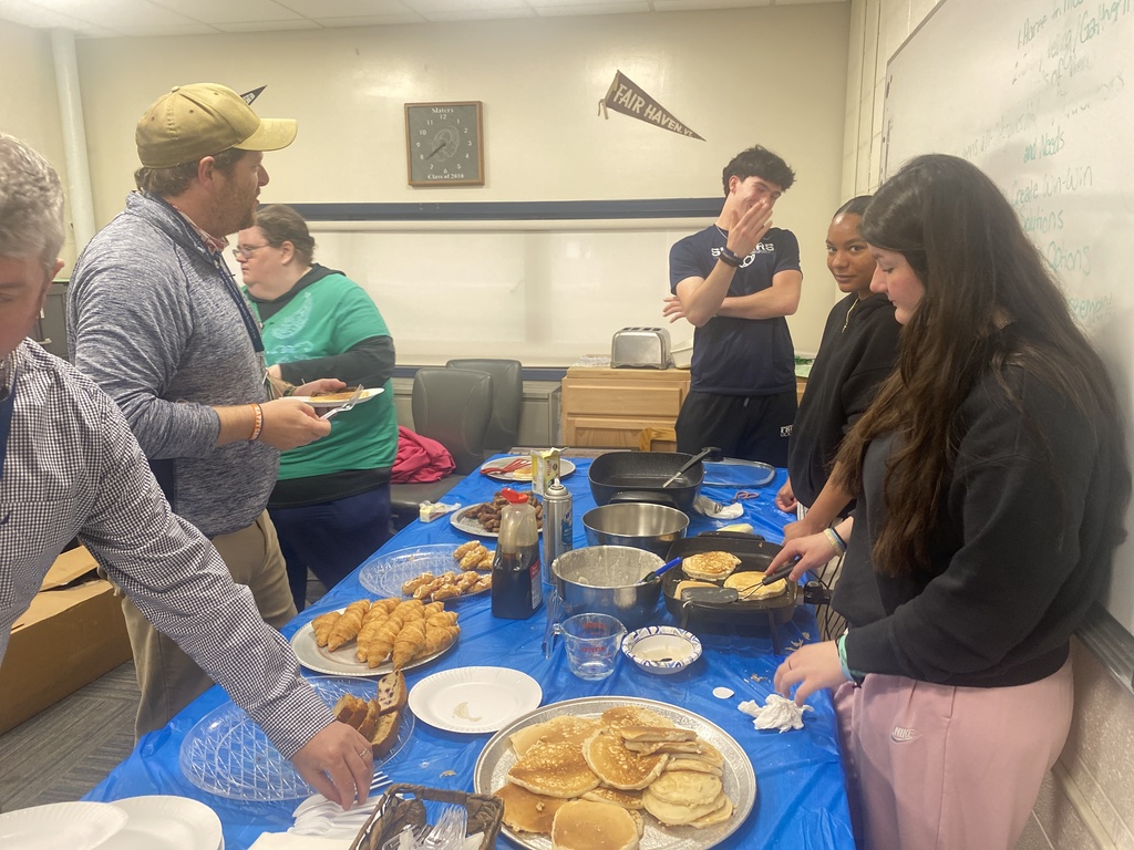 FHUMHS Student Council members prepare and serve breakfast in a classroom filled with pancakes, pastries, sausage, and other breakfast foods during Teacher and Staff Appreciation Week.