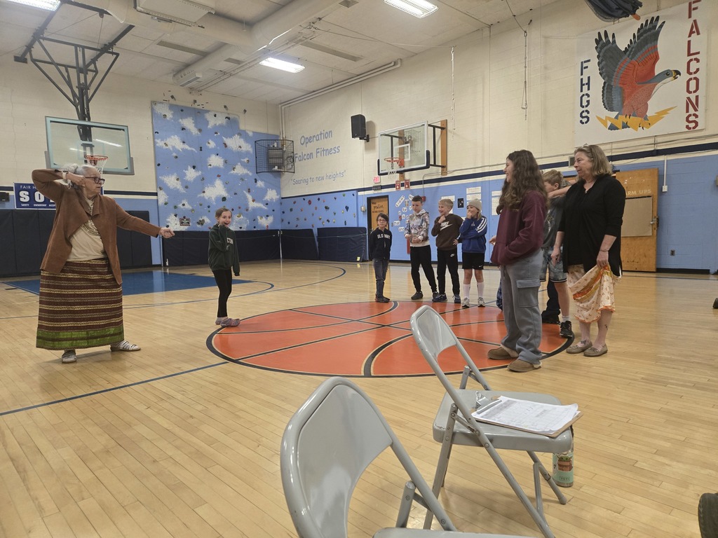 Miss Lucy Neel demonstrates traditional Abenaki storytelling and movement activities in the school gym while students and staff watch and participate.