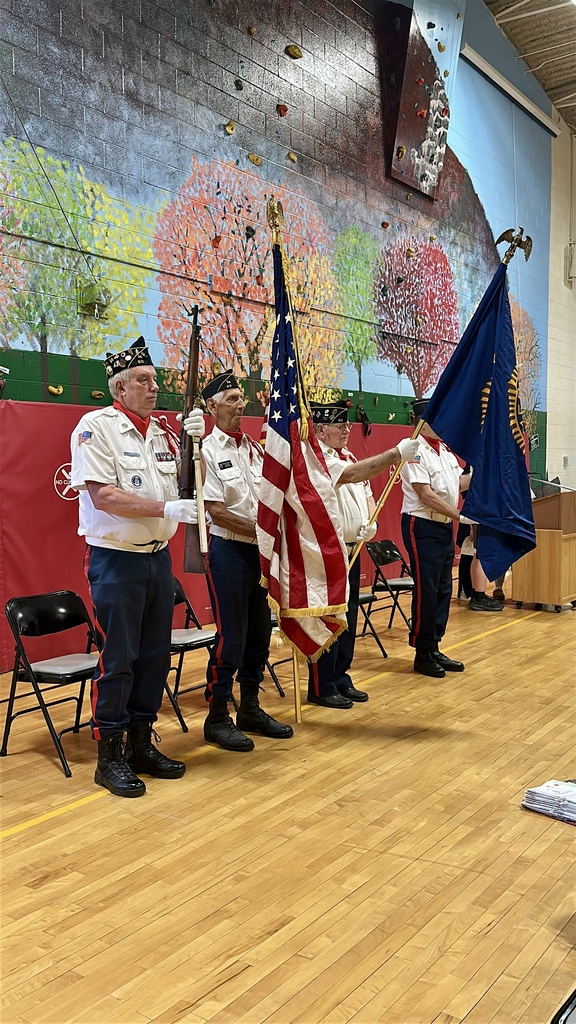 Members of the Crippen-Fellows Post 50 Color Guard stand in formation holding the American flag and ceremonial flags during the Memorial Day assembly.