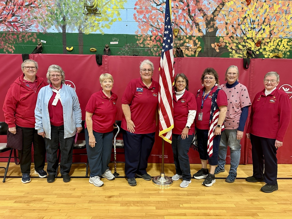 Members of the American Legion Auxiliary pose together for a group photo in the school gymnasium during the Memorial Day event.