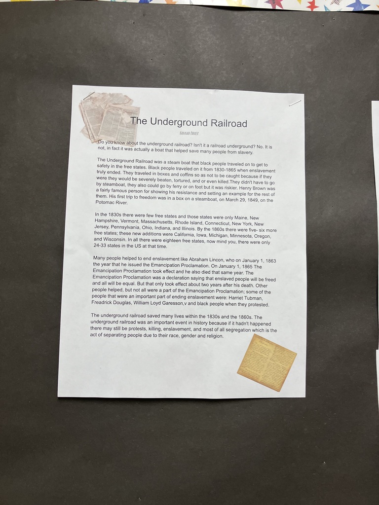  A close-up photograph of a student-written research paper titled "The Underground Railroad" by Hannah Parker, stapled to a black bulletin board. The paper features clip art of vintage newspaper clippings in the top left corner and a yellowed historical document in the bottom right corner.  The typed text includes paragraphs explaining that the Underground Railroad was not an actual railroad underground, but a network that included steamboats, wagons, and foot travel to help enslaved people escape to free states between 1830 and 1865. It mentions Henry "Box" Brown escaping in a box on March 29, 1849. It lists free states in the 1830s and 1860s, and discusses Abraham Lincoln's Emancipation Proclamation taking effect on January 1, 1863. It concludes by naming important figures like Harriet Tubman, Frederick Douglass, and William Lloyd Garrison. 
