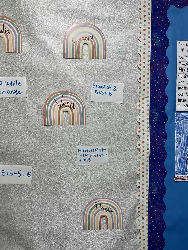 A close-up view of the right-center portion of the glittery silver bulletin board, showing the right edge of the paper quilt and several student name tags. Visible names include Khalia and Ari. The handwritten math notes scattered around them read: "60 blue triangles," "60 white triangles," "1 white triangle and 1 blue triangle = 1 square," "60 white rectangles," and the addition equation "5+5+5=15