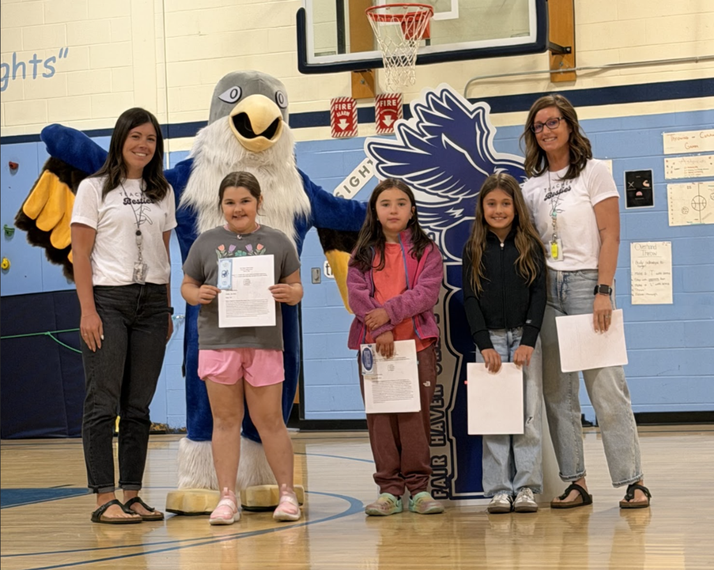 Three students holding certificates pose with two staff members and the Falcon mascot during a Fair Haven Grade School recognition event.