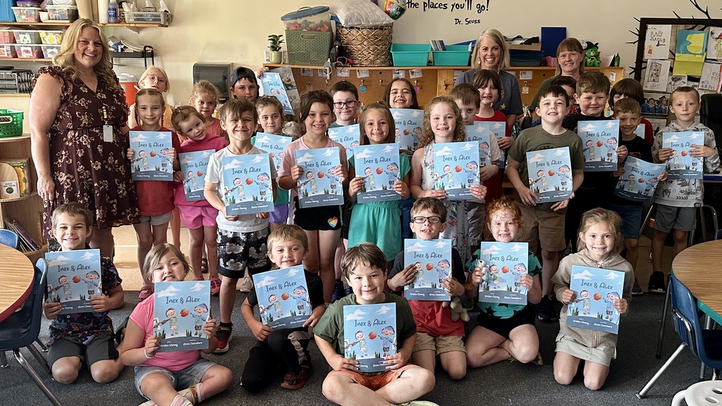 A class photo shows first-grade students holding their copies of Inex & Alex alongside author Kristen Ramey and classroom staff.