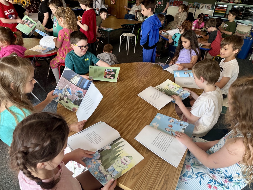 Students sit around classroom tables reading and sharing copies of Inex & Alex after the author visit.