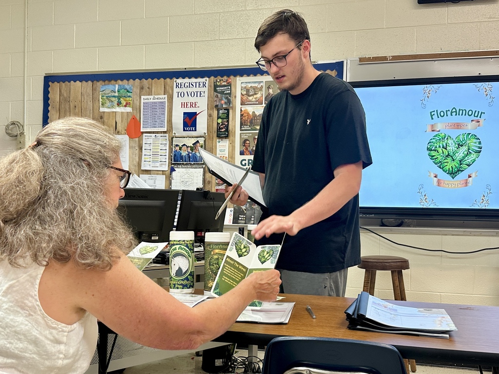 A Fair Haven Union High School student presents marketing materials and business recommendations to client Sue Cook during an Innovation & Entrepreneurship class presentation.