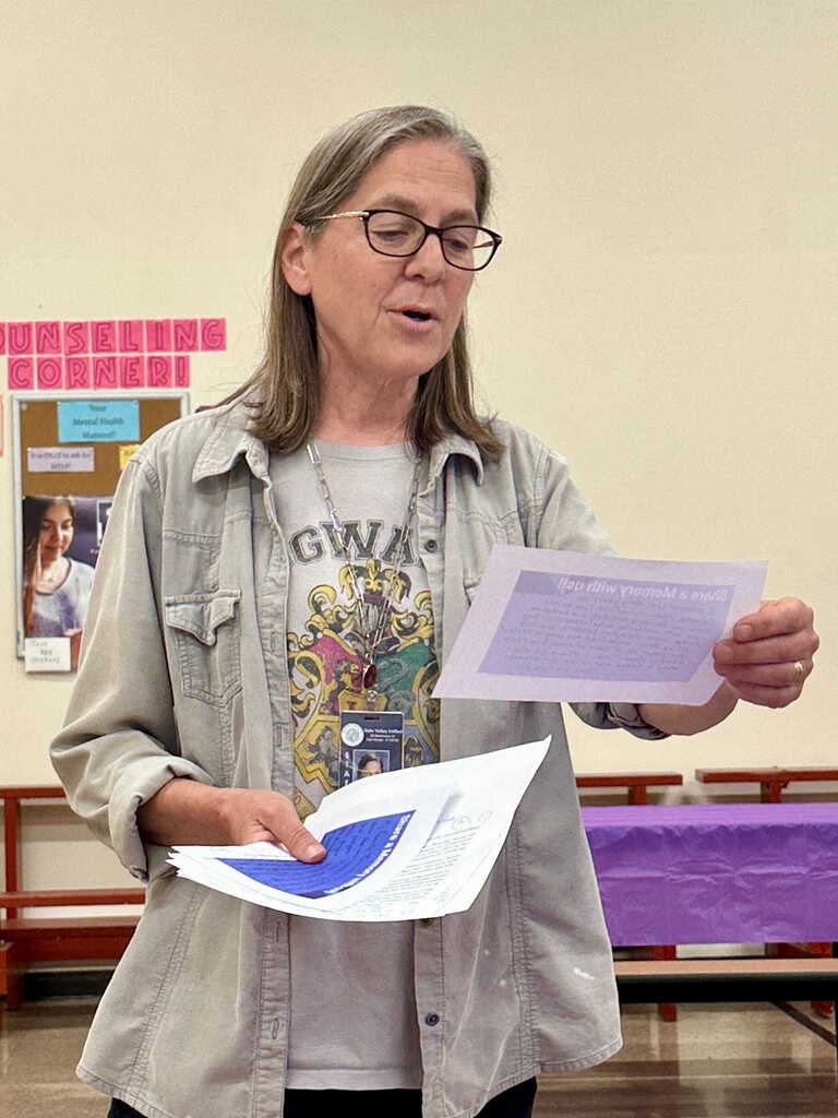 A staff member reads from prepared remarks while sharing memories and well wishes during Tina Rampone's retirement celebration.