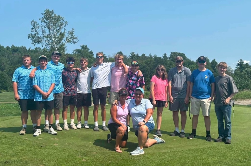 Group of students, adults, and event supporters pose together on the putting green during the Senior Class Golf Fundraiser at Milestone Golf Course on a sunny day.