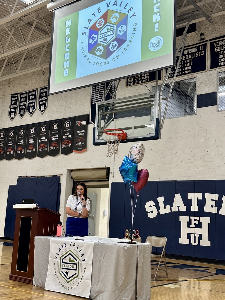 Superintendent Brooke Olsen-Farrell addresses faculty and staff during Slate Valley’s Opening Day Inservice beneath a district welcome screen.