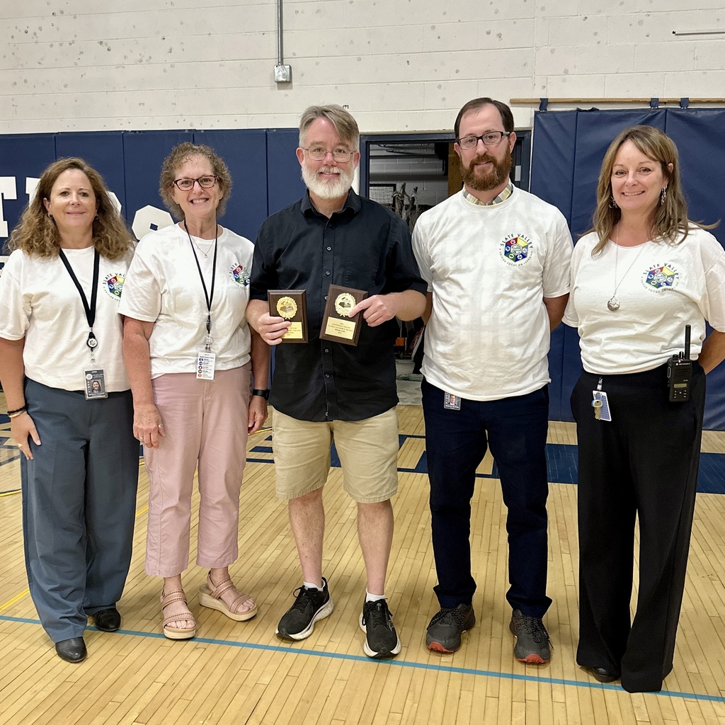 FHUHS Special Education teacher Michael Lenox holds his UVM Outstanding Teacher awards while posing with district administrators.