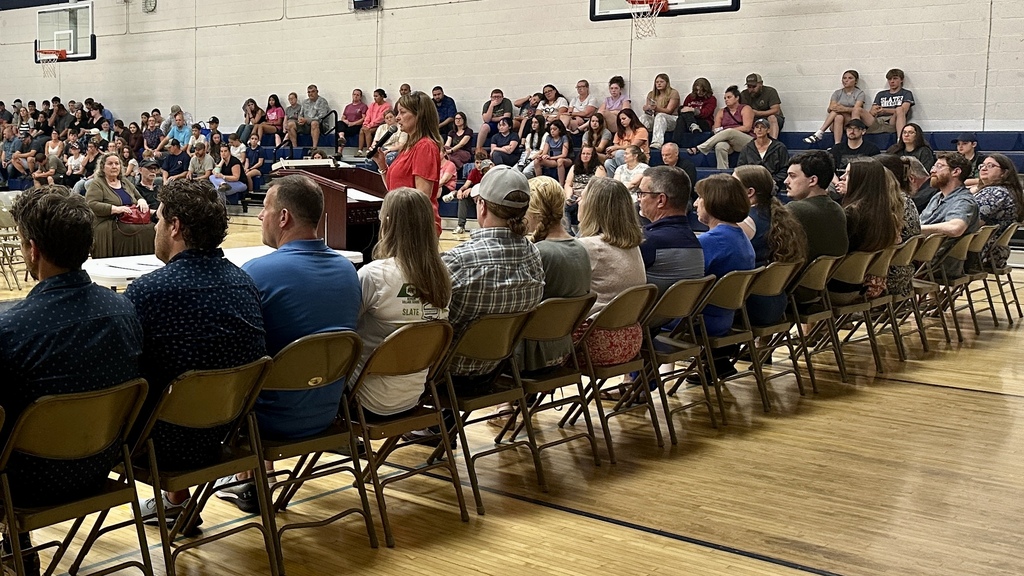 Principal Jennefer Paquette addresses a large crowd of students and families gathered in the gym for Middle School Open House.