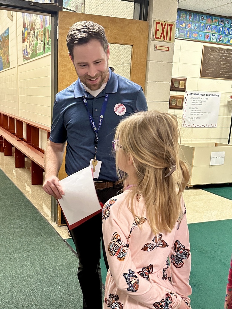 A CES staff member smiles while talking with a student in the hallway during Open House.