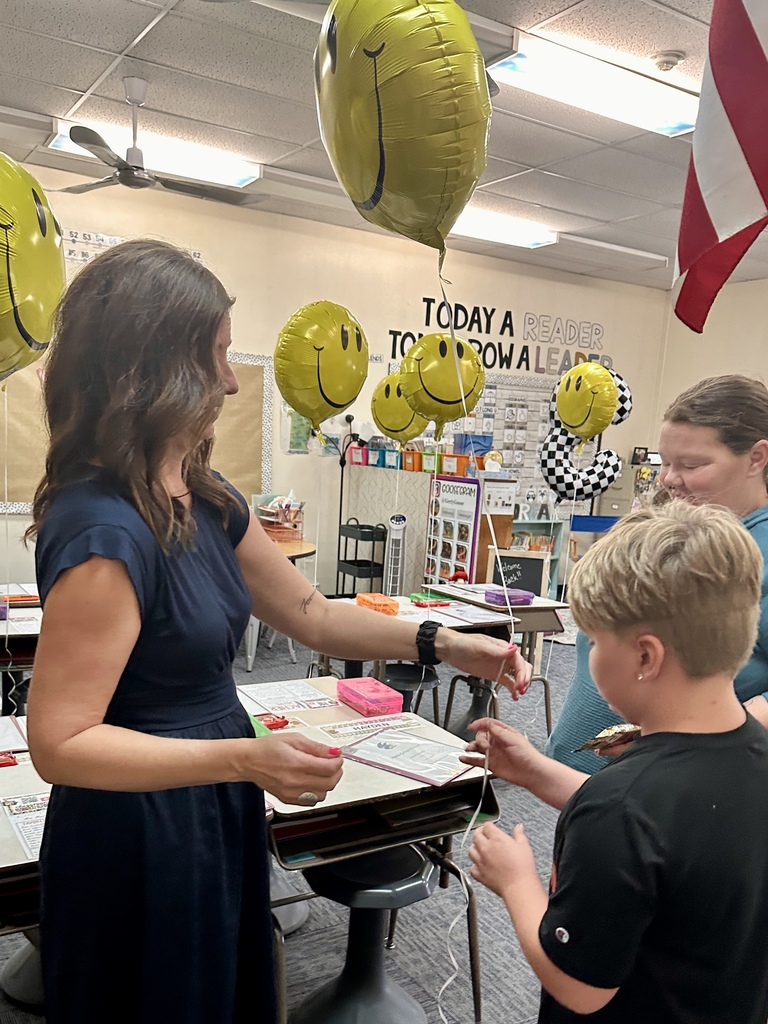 FHGS student receives a smiley-face balloon while visiting a decorated classroom during Open House.