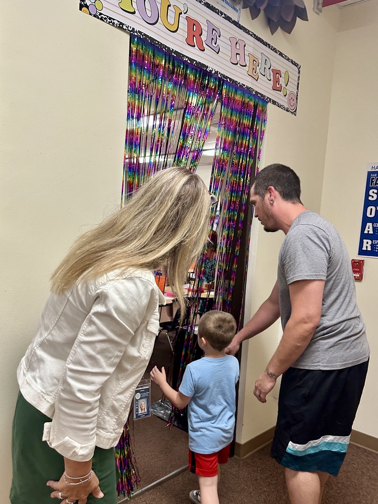 FHGS student and family enter a colorful classroom decorated with a “You’re Here!” sign.