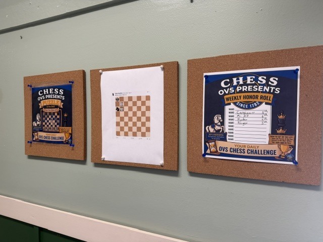 Three corkboards displayed in an Orwell Village School hallway feature the OVS Chess Challenge, a weekly chess puzzle and a handwritten honor roll.