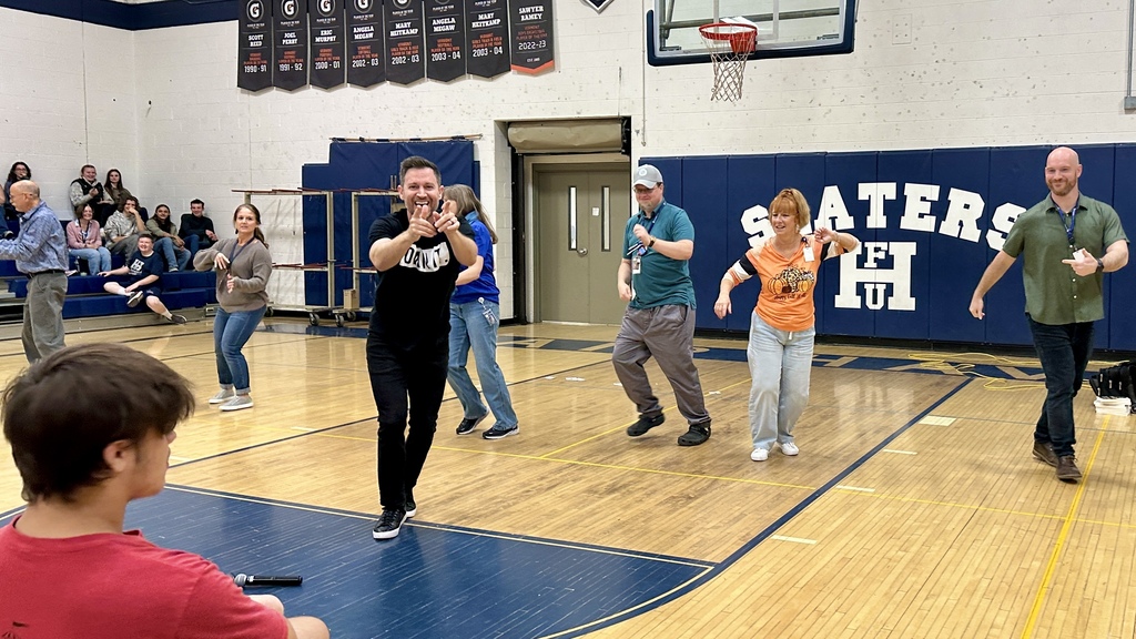Speaker Brandon Lee White leading Fair Haven faculty and staff members in a Salsa dance on the gymnasium floor.