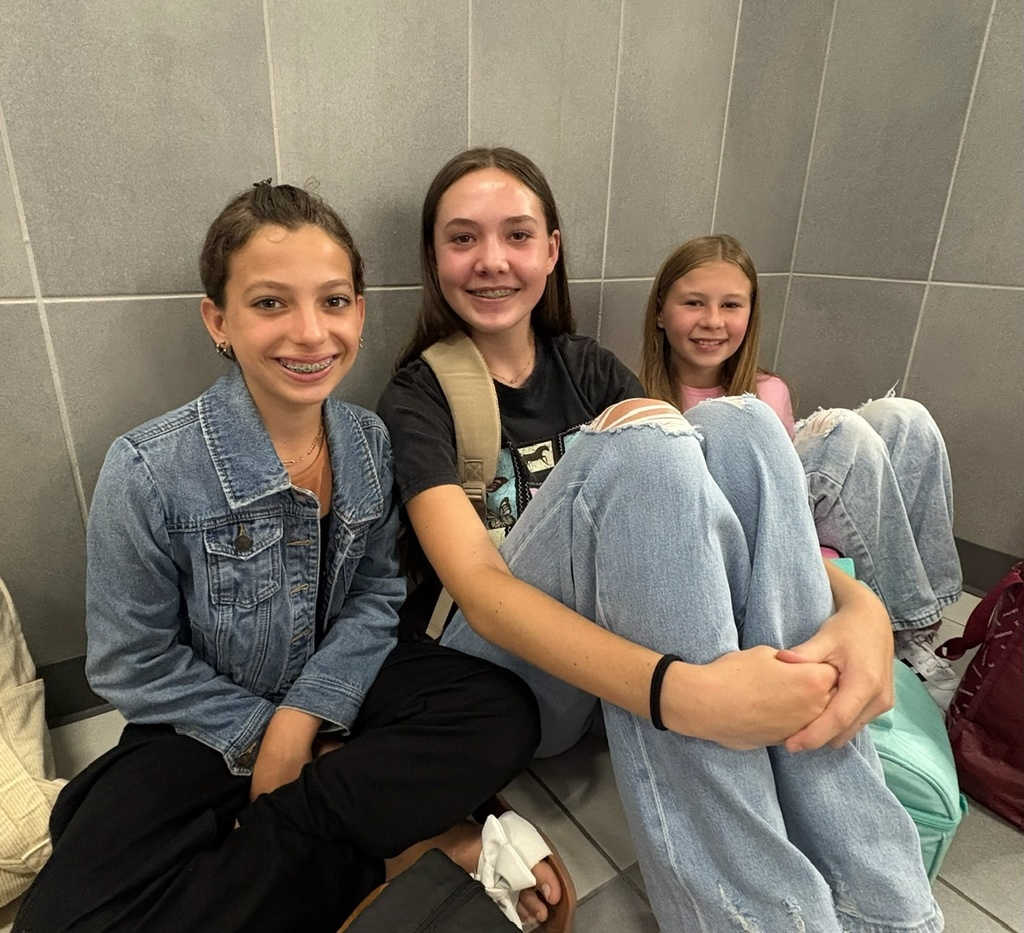 students sitting against wall