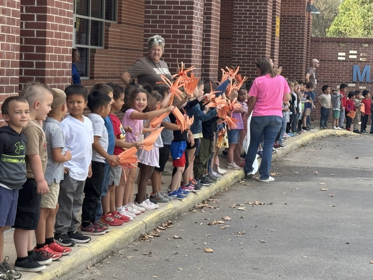 students waving orange papers