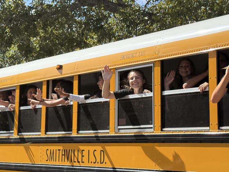 runners waving out bus window
