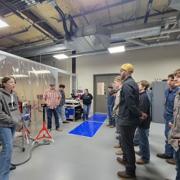 students talking to welder
