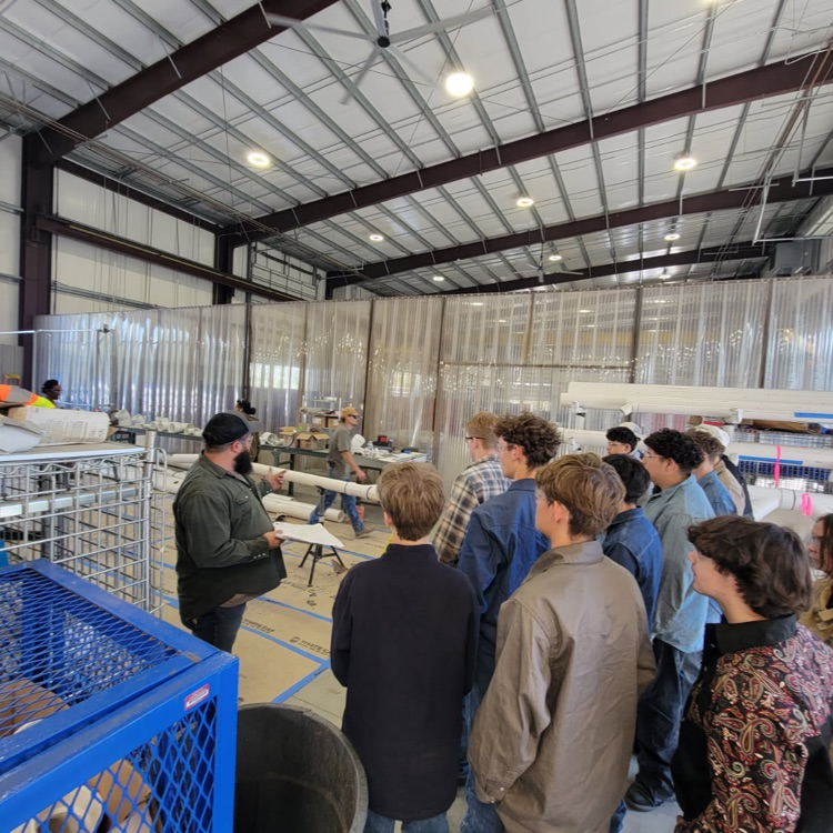 students talking to welder