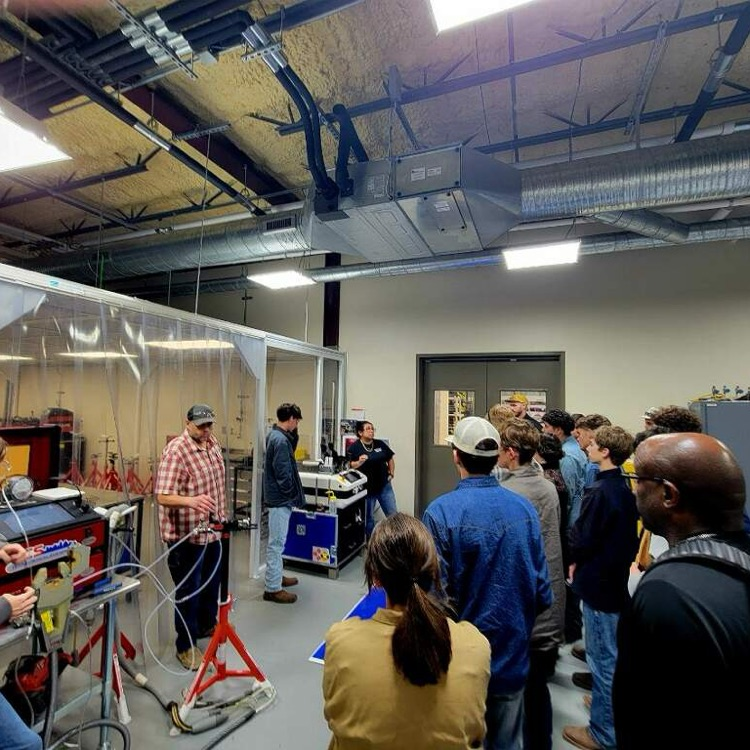 students talking to welder