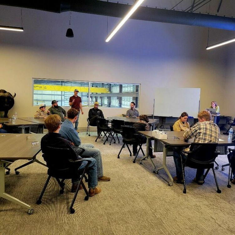 students talking to welder