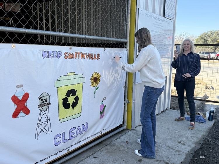 student signing artwork