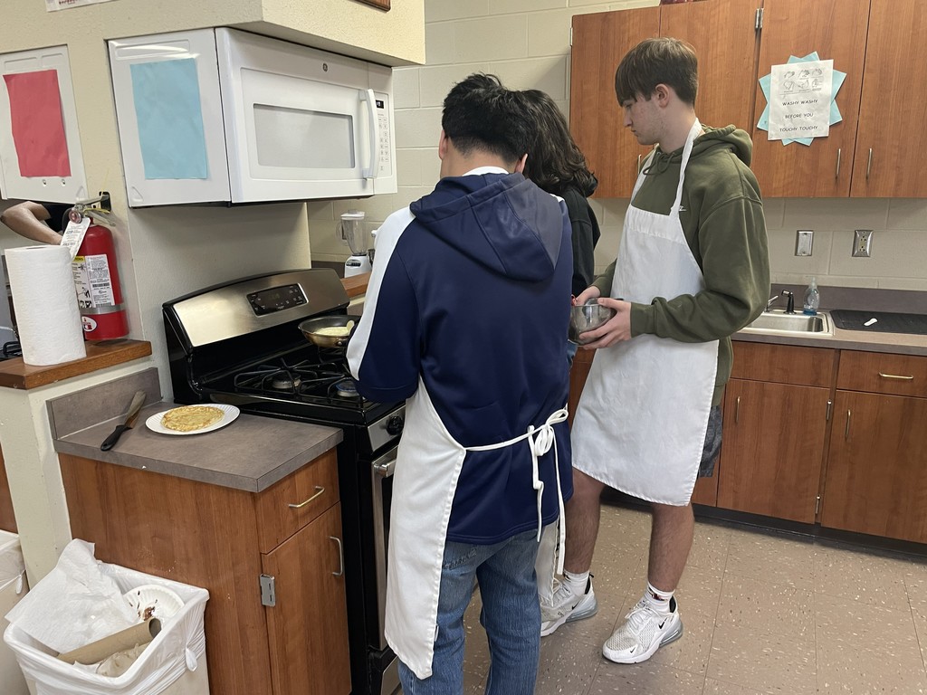 students cooking pancakes on the stovetop