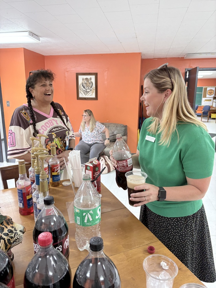 two ladies looking at each other and laughing